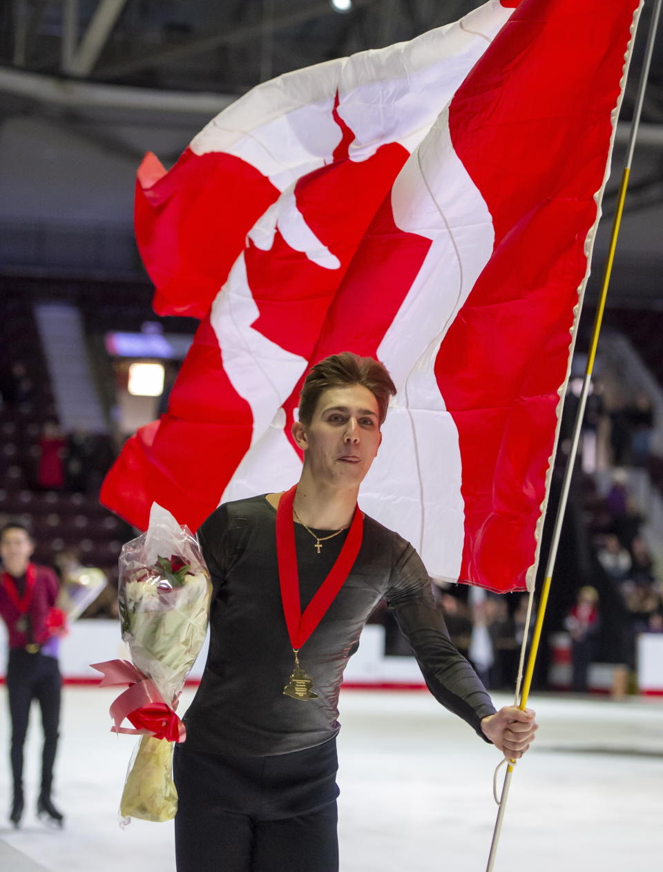 Roman Sadovsky does a victory lap with his medal after winning the men's title at the Canadian figure skating championships in Mississauga, Ontario, Saturday, Jan. 18, 2020. (Frank Gunn/The Canadian Press via AP)