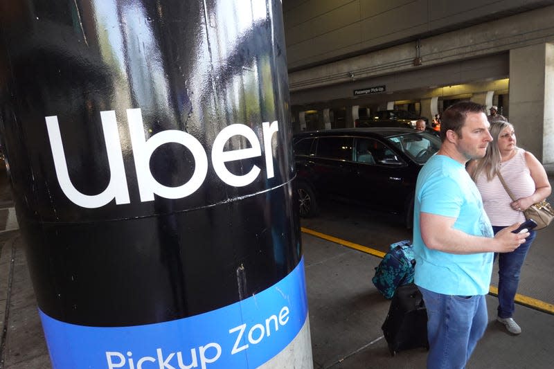 ravelers wait for an Uber ride at Midway International Airport on May 09, 2022 in Chicago, Illinois. Uber plans to cut spending and hiring in an attempt slow the company’s plummeting stock price, which is down nearly 50 percent for the year.