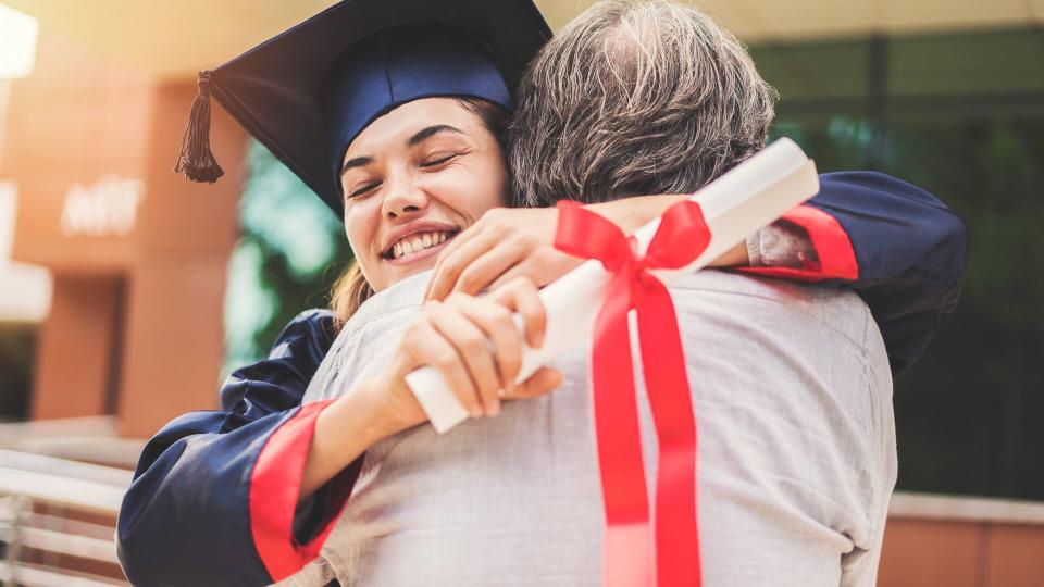 Graduated student hugging her father.