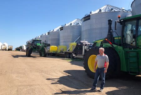 Farmer Mike Appert stands in front of some of his storage bins and machinery on his 48,000-acre farm in Hazelton, North Dakota