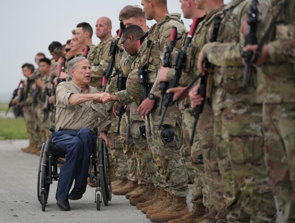 Gov. Greg Abbott greets Texas Army National Guard troops deploying from Austin-Bergstrom International Airport on Monday to secure the Texas-Mexico border in anticipation of the end of Title 42 later this week.