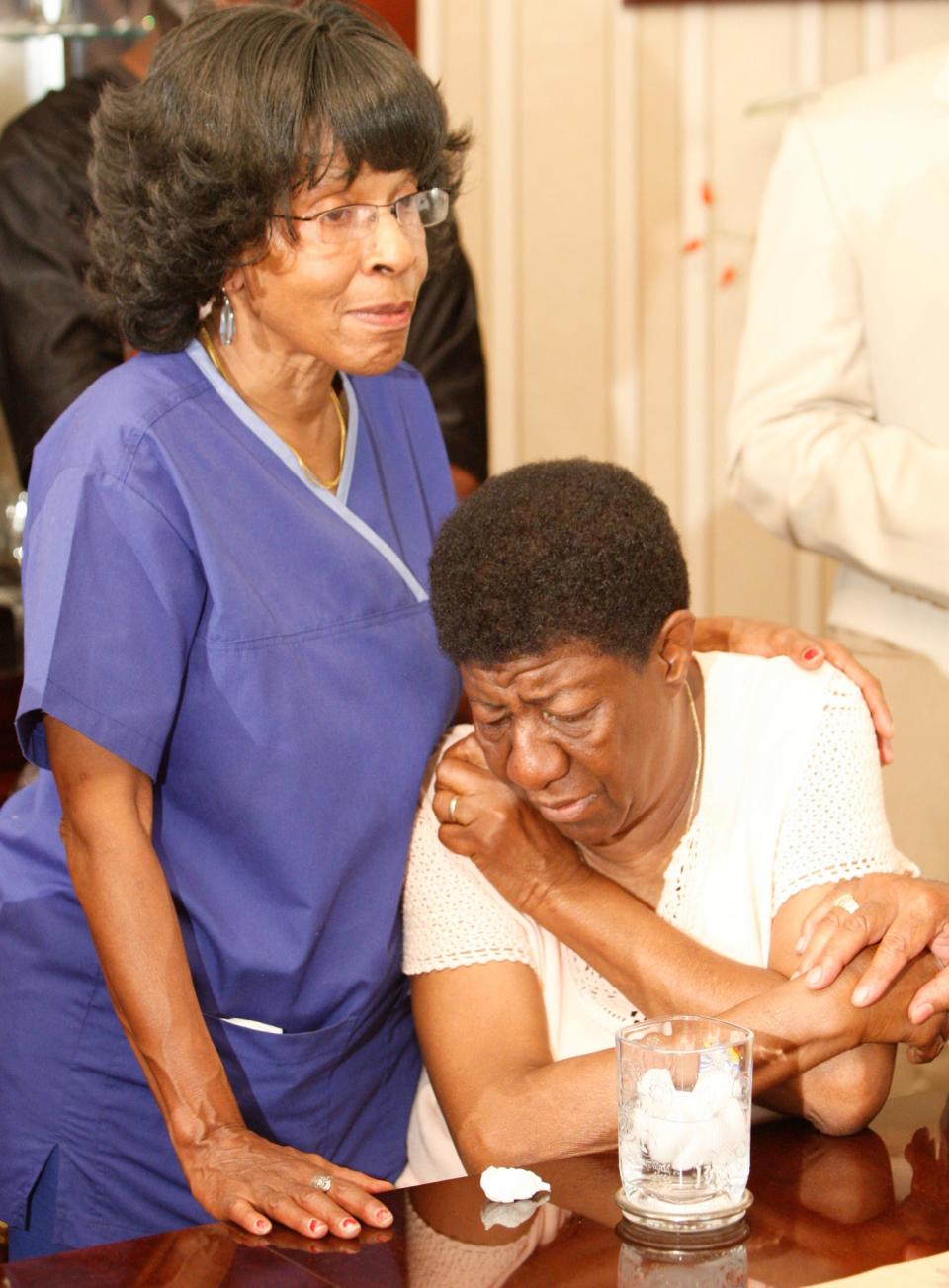 Rev. Coleman's sister Ellen Beard, left, consoles Mattie Jones, a longtime friend of Coleman and fellow activist at a news press conference yesterday, about the death of Rev. Louis Coleman. 