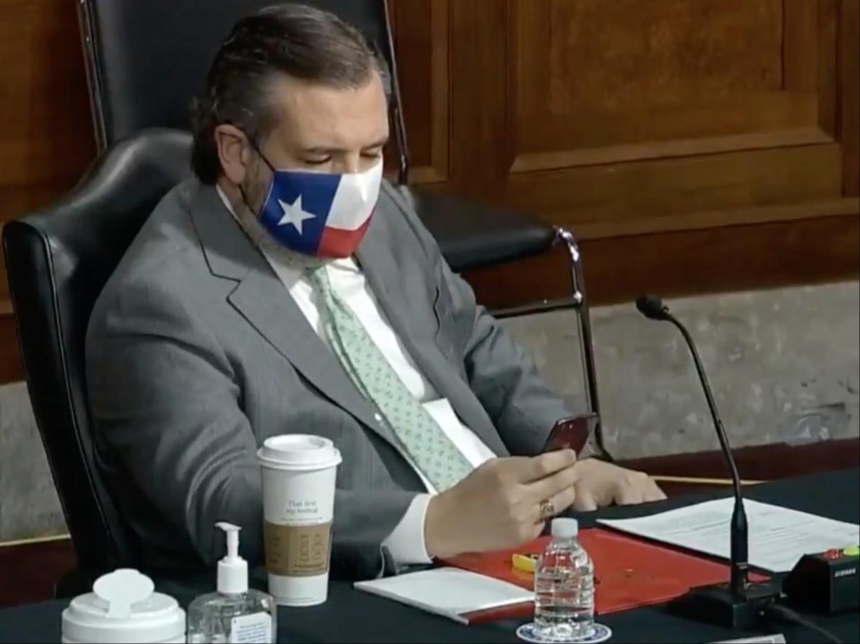 Ted Cruz on his phone during the Senate Homeland Security and Rules committees hearings on the Capitol riots ((C-Span))