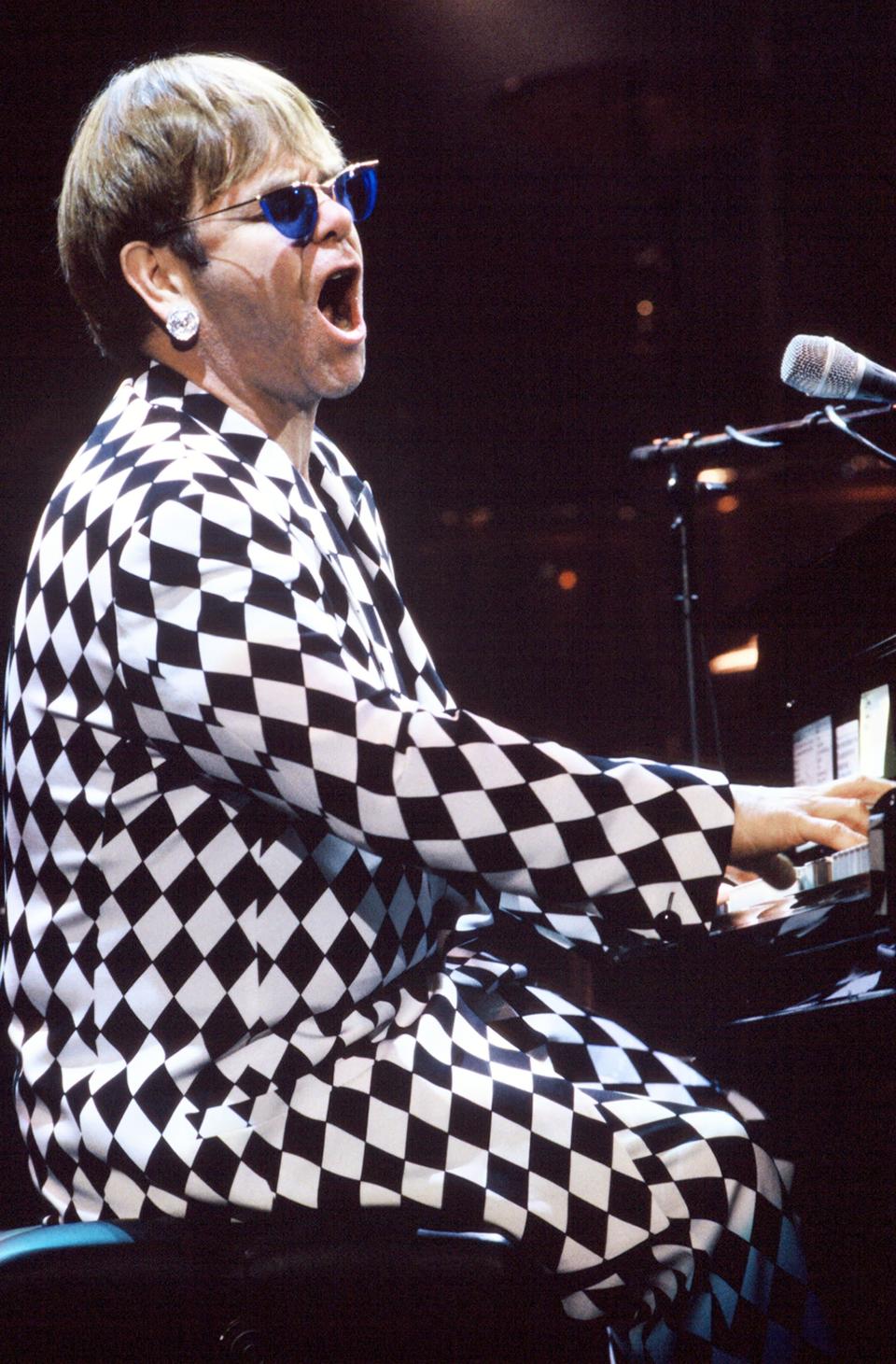 <p>Elton John had some of his most famous fashion moments onstage, and this checkerboard look complete with dazzling stud earrings and translucent blue lenses at Shoreline Ampitheatre in CA was particularly memorable.</p>