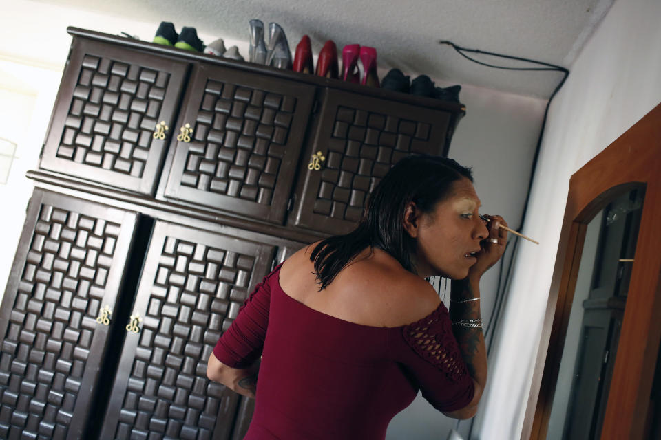In this Aug. 17, 2019 photo, trans rights activist Kenya Cuevas applies makeup as she prepares to go out, in Chalco, Mexico. President Andrés Manuel López Obrador promises his government will carry out "effective" investigations into LGBTQ hate crimes, but the rate continues apace with 16 more killings of trans women slain in the first four months of 2019. (AP Photo/Ginnette Riquelme)