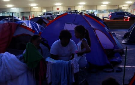 Central American migrants are seen outside their tents in an encampment in Matamoros