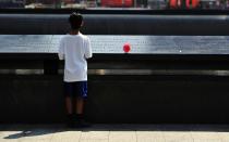 A boy looks at names on the South reflecting pool at the 9/11 Memorial during ceremonies marking the 12th anniversary of the 9/11 attacks on the World Trade Center in New York, September 11, 2013. REUTERS/Stan Honda/Pool (UNITED STATES - Tags: ANNIVERSARY DISASTER)