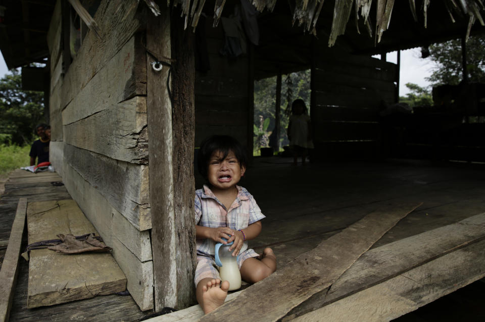 A boy of the Ngabe Bugle indigenous group sits at his home in the community of El Terron, Panama, Friday, Jan. 17, 2020. A pregnant woman, five of her children and a neighbor where round up by about 10 lay preachers at the hamlet on Monday and tortured, beaten, burned and hacked with machetes to make them "repent their sins", authorities said. (AP Photo/Arnulfo Franco)