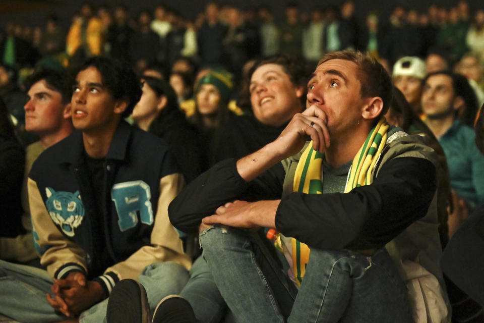 People react while watching the live screening of the Women's World Cup semifinal soccer match between Australia and England at Stadium Australia, as they gather at Tumbalong Park in Sydney, Australia, Wednesday, Aug. 16, 2023. (Steven Saphore/AAP Image via AP)