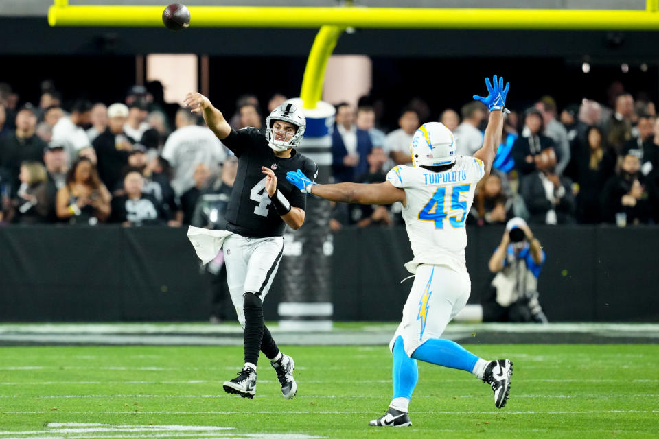 Dec 14, 2023; Paradise, Nevada, USA; Las Vegas Raiders quarterback Aidan O’Connell (4) throws a pass against Los Angeles Chargers linebacker <a class="link " href="https://sports.yahoo.com/nfl/players/40077" data-i13n="sec:content-canvas;subsec:anchor_text;elm:context_link" data-ylk="slk:Tuli Tuipulotu;sec:content-canvas;subsec:anchor_text;elm:context_link;itc:0">Tuli Tuipulotu</a> (45) in the third quarter at Allegiant Stadium. Mandatory Credit: Stephen R. Sylvanie-USA TODAY Sports