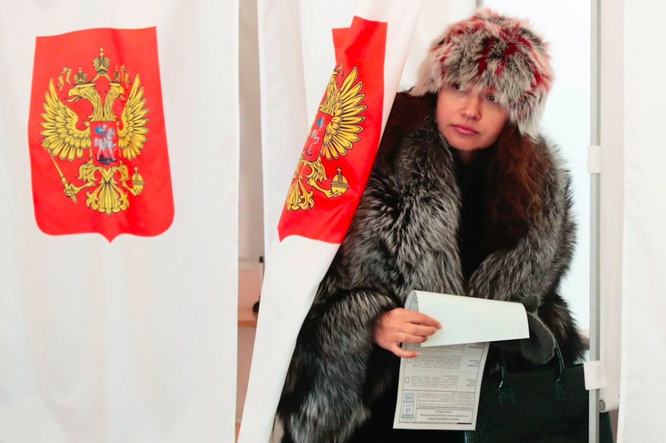 <em>A woman exits a polling booth in Moscow as she prepares to vote (PA)</em>