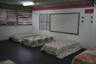 Beds sit inside a classroom of a primary school inside the Sambadrome, repurposed as a shelter to house the homeless amid the spread of the new coronavirus in Rio de Janeiro, Brazil, Monday, March 30, 2020. (AP Photo/Leo Correa)