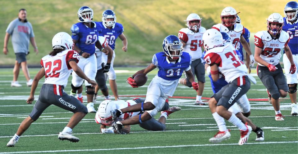 Cooper running back Daniel Bray eludes a defender en route to a 50-yard TD run during the Coogs' scrimmage with Odessa High on Thursday at Shotwell Stadium. The play was called back because of a holding penalty.