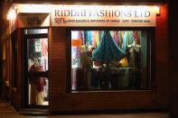 LEICESTER, UNITED KINGDOM - NOVEMBER 13: A woman looks out from her saree shop to watch fireworks during the Hindu festival of Diwali on November 13, 2012 in Leicester, United Kingdom. Up to 35,000 people attended the Diwali festival of light in Leicester's Golden Mile in the heart of the city's asian community. The festival is an opportunity for Hindus to honour Lakshmi, the goddess of wealth and other gods. Leicester's celebrations are one of the biggest in the world outside India. Sikhs and Jains also celebrate Diwali. (Photo by Christopher Furlong/Getty Images)