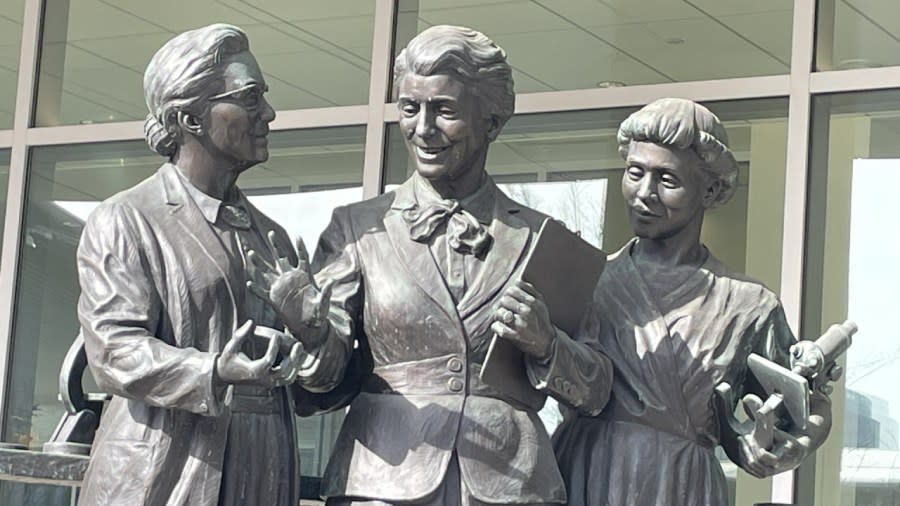 A bronze statue featuring Pearl Kendrick, Grace Eldering and Loney Clinton Gordon.