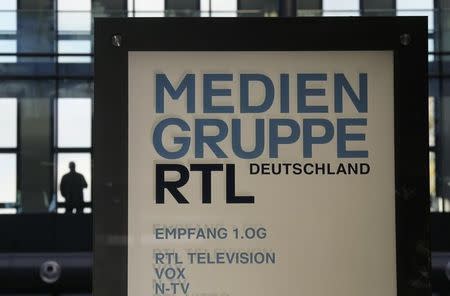 A man stands in a window of the headquarters of RTL Media Group Germany in Cologne November 12, 2012. REUTERS/Wolfgang Rattay