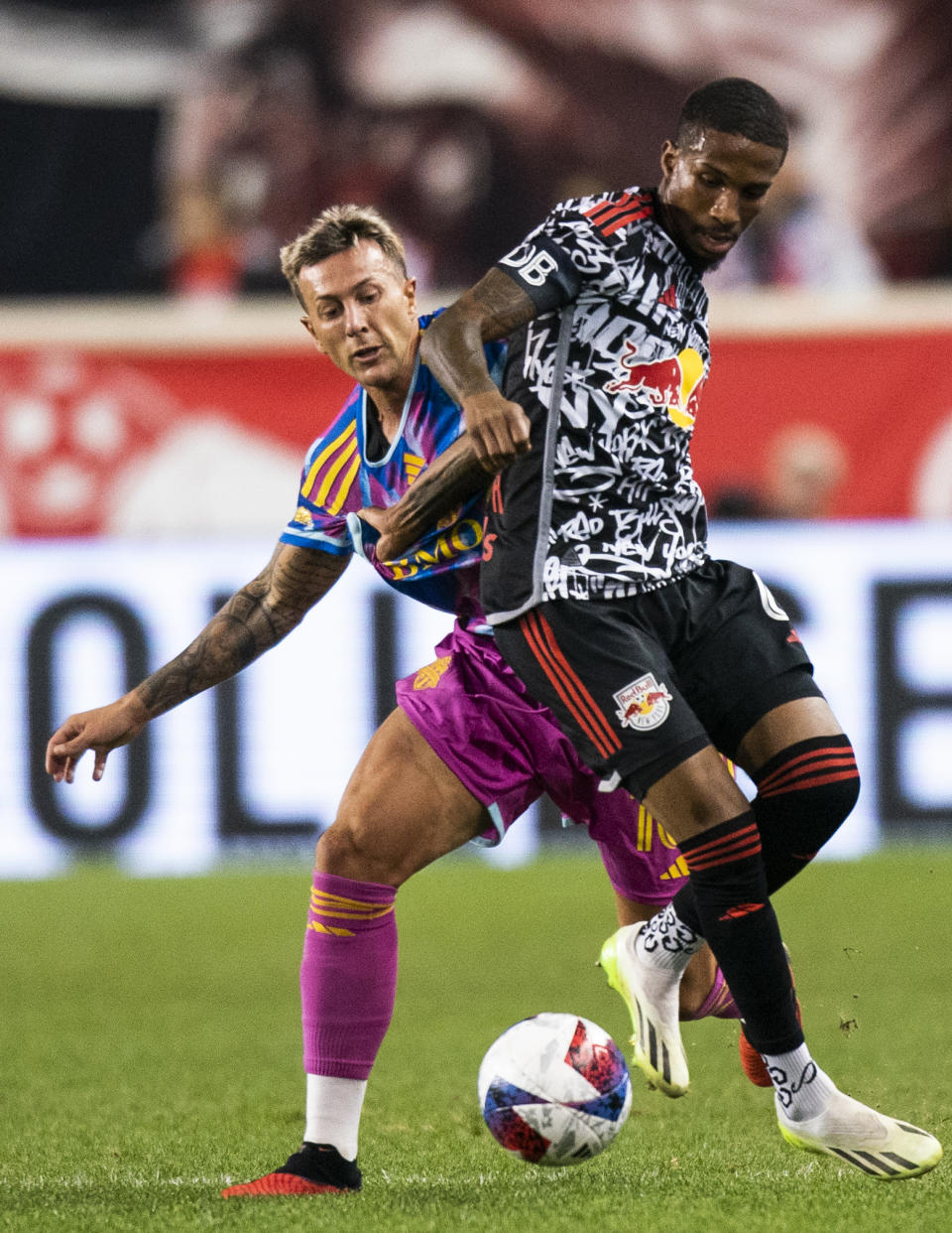 Toronto FC forward Federico Bernardeschi, left, fights for the ball against New York Red Bulls defender Kyle Duncan, right, during an MLS soccer match Saturday, Oct. 7, 2023, in Harrison, N.J. (AP Photo/Eduardo Munoz Alvarez)