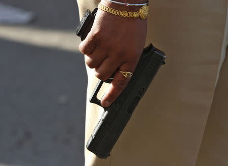 An Indian security personnel carries a pistol while standing on guard outside the Indian Air Force (IAF) base at Pathankot in Punjab, India, January 2, 2016. REUTERS/Mukesh Gupta