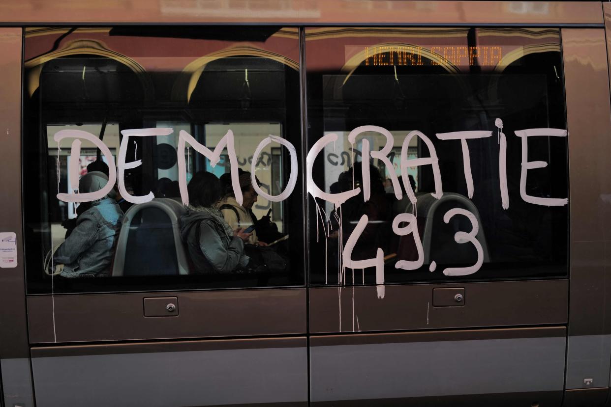 A  message that reads, 'Democracy 49.3', is daubed on the side one a tram carriage as demonstration take place across France after the government pushed a pensions reform through parliament without a vote, using the article 49.3 of the constitution, in Nice, southern France, on March 28, 2023. - France faces another day of strikes and protests nearly two weeks after the president bypassed parliament to pass a pensions overhaul that is sparking turmoil in the country, with unions vowing no let-up in mass protests to get the government to back down. The day of action is the tenth such mobilisation since protests started in mid-January against the law, which includes raising the retirement age from 62 to 64. (Photo by Valery HACHE / AFP) (Photo by VALERY HACHE/AFP via Getty Images) ORIG FILE ID: AFP_33C78MC.jpg