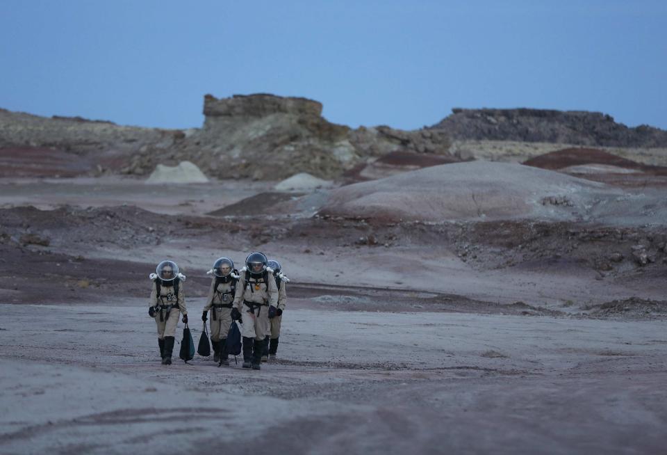 Members of Crew 125 EuroMoonMars B mission return after collecting geologic samples for study at the Mars Desert Research Station (MDRS) in the Utah desert March 2, 2013. The MDRS aims to investigate the feasibility of a human exploration of Mars and uses the Utah desert's Mars-like terrain to simulate working conditions on the red planet. Scientists, students and enthusiasts work together developing field tactics and studying the terrain. All outdoor exploration is done wearing simulated spacesuits and carrying air supply packs and crews live together in a small communication base with limited amounts of electricity, food, oxygen and water. Everything needed to survive must be produced, fixed and replaced on site. Picture taken March 2, 2013. REUTERS/Jim Urquhart (UNITED STATES - Tags: SCIENCE TECHNOLOGY SOCIETY ENVIRONMENT) ATTENTION EDITORS: PICTURE 27 OF 31 FOR PACKAGE 'MARS IN THE DESERT' SEARCH 'JIM MARS' FOR ALL IMAGES