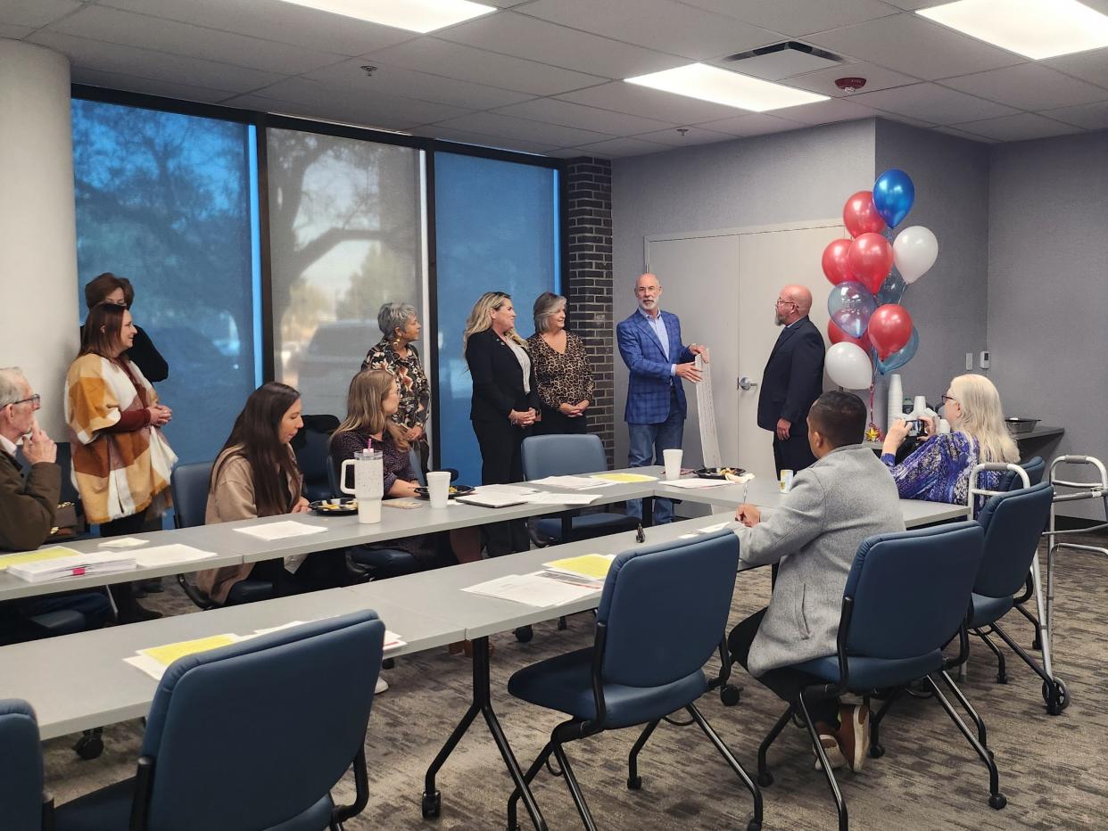Family Support Services CEO Jim Womack (right) accepts a $50,000 grant from Bank of America representatives during a Wednesday board meeting held in the FSS, conference room, located at 2209 SW 7th Ave.