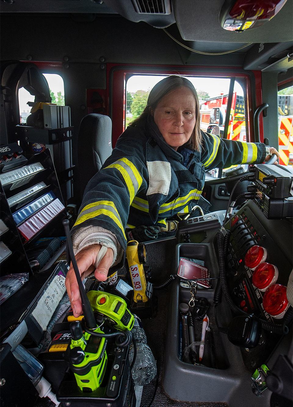 Engineer Lynn Kirkner, 57, a firefighter with the Hartsville Fire Company, in Warminster, on Wednesday, July 27, 2022, reaches for the radio as she settles in the fire truck's driver's seat.