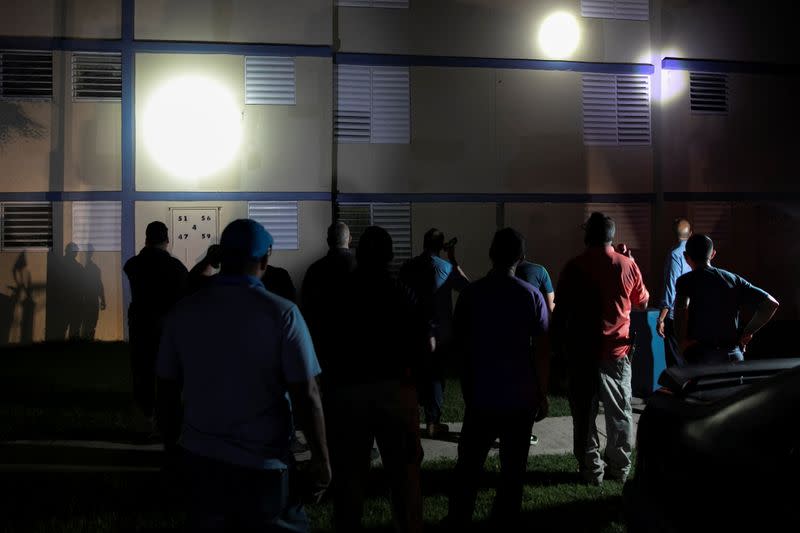 Emergency workers inspect a damaged building after an earthquake in Yauco