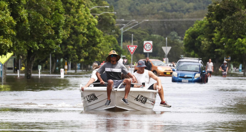 men on boat Flooding is seen in Chinderah, Northern NSW, Tuesday, March 1, 2022. More severe weather is expected along the NSW coast. (AAP Image/Jason O&#39;Brien) NO ARCHIVING
