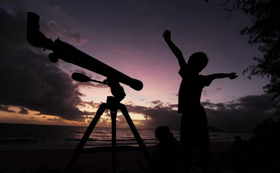 PALM COVE, AUSTRALIA - NOVEMBER 14: A young boy gets ready to view the solar eclipse with his telescope on November 14, 2012 in Palm Cove, Australia. Thousands of eclipse-watchers have gathered in part of North Queensland to enjoy the solar eclipse, the first in Australia in a decade. (Photo by Ian Hitchcock/Getty Images)