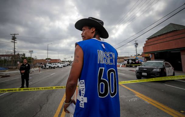 PHOTO: Herman 'Cowboy' Douglas, business partner of Nipsey Hussle, stands behind police crime scene tape to pay his respect at a makeshift memorial for Hussle outside their clothing store, April 2, 2019, in Los Angeles.  (Los Angeles Times via Getty Images, FILE)