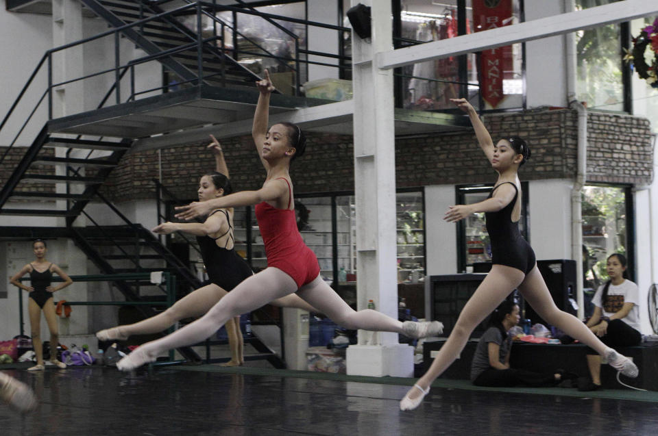 In this photo taken Nov. 25, 2012, Filipino slum dweller Jessa Balote, center, practices with other students during a class at Ballet Manila in the Philippine capital. Balote, who used to tag along with her family as they collect garbage at a nearby dumpsite, is a scholar at Ballet Manila's dance program. As an apprentice, she makes around 7,000 pesos ($170) a month, sometimes double that, from stipend and performance fees. (AP Photo/Aaron Favila)