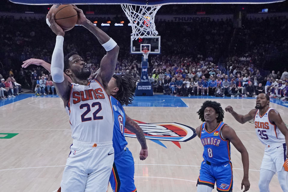 Phoenix Suns center Deandre Ayton (22) goes up for a dunk in front of Oklahoma City Thunder forward Jaylin Williams (6) and forward Jalen Williams (8) in the first half of an NBA basketball game Sunday, April 2, 2023, in Oklahoma City. (AP Photo/Sue Ogrocki)