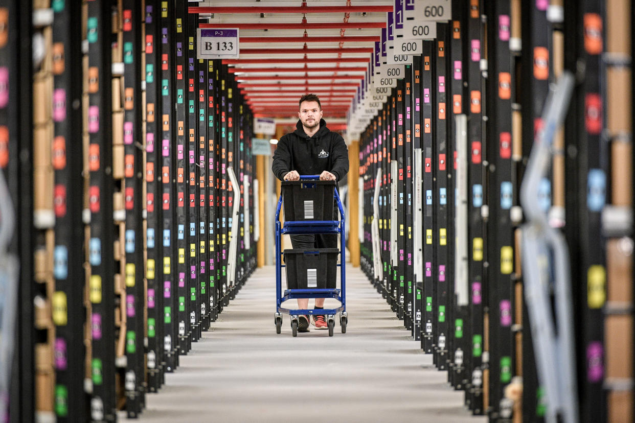 A worker walks between thousands of racks at Amazon's fulfillment centre in Swansea. Photo: Ben Birchall/PA Archive/PA Images