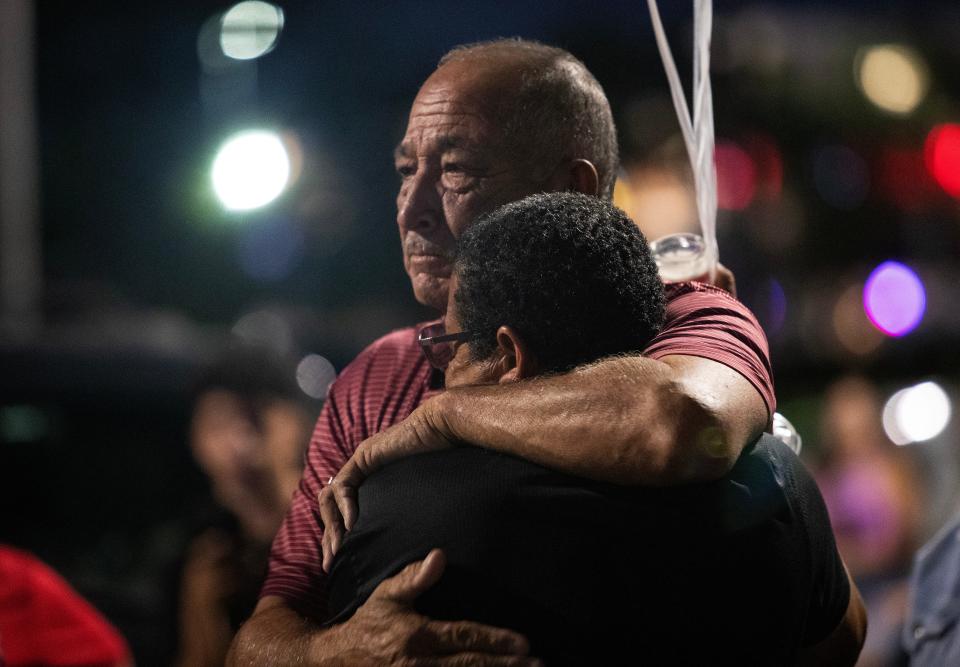 Miguel Rodriguez and Mark Coleman embrace on Thursday night, June 29, 2023, at a memorial for the five teenagers who died on Sunday night or Monday morning when their car crashed into a Fort Myers pond. The memorial and vigil were held at the Texas Roadhouse restaurant where four of them worked.