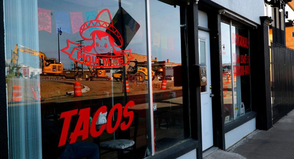 Heavy construction equipment for the Lewis Street overpass project is reflected in the window of the Piqui Tacos Mexican restaurant at 218 W. Lewis Street in Pasco.