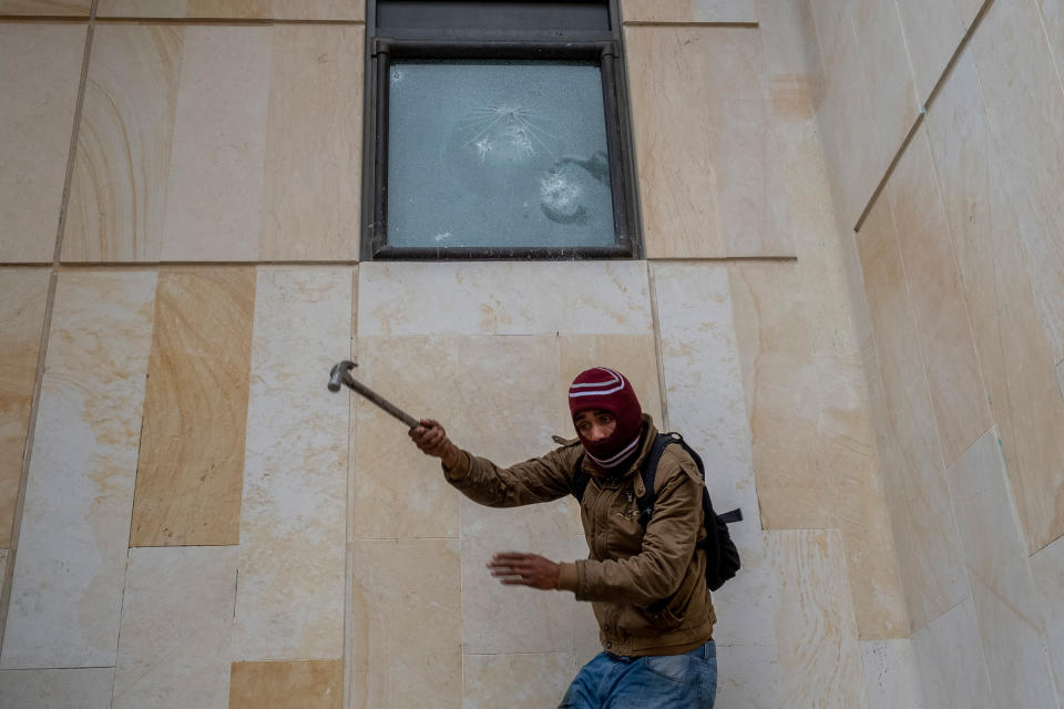 A protestor breaks a window at the Supreme Court Of Justice in downtown Bogotá on April 28.<span class="copyright">Santiago Mesa—Reojo Colectivo</span>