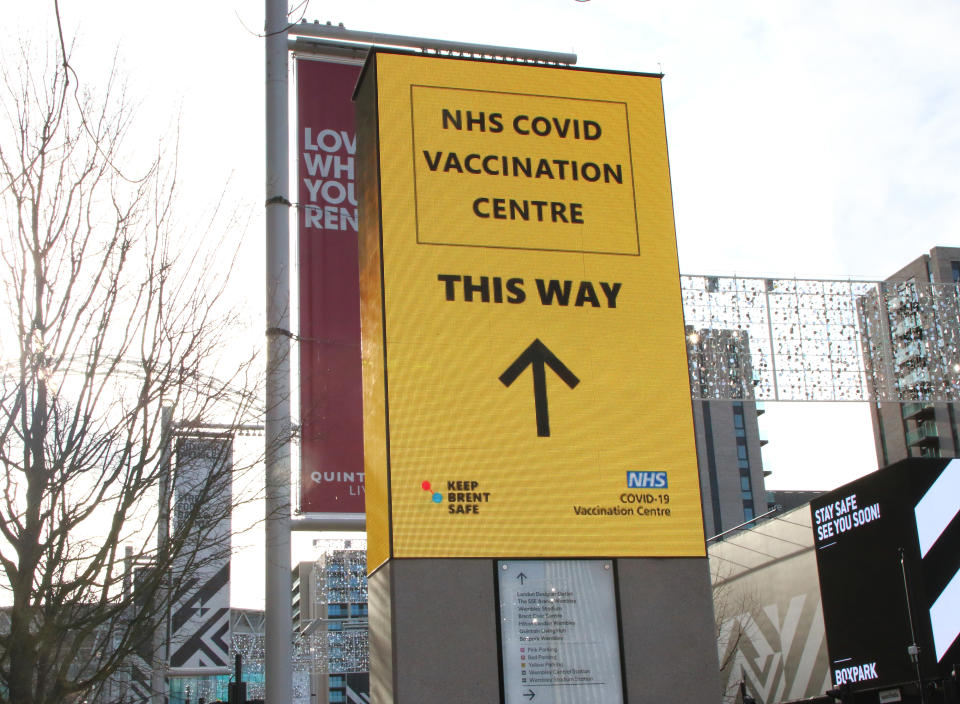 LONDON, UNITED KINGDOM - 2021/01/21: Signage directs the public to the NHS vaccination centre. A steady stream of elderly people with pre-booked appointments at the new Covid-19 Vaccination hub at the Olympic Office Centre, near London's Wembley Stadium.  It is one of 10 new large scale Vaccination centres opened this week, to join the seven already in use across the country. So far 4.9 million people across the UK have received the first dose of vaccine and the government aims for that number to rise to 15 million by 15 February. (Photo by Keith Mayhew/SOPA Images/LightRocket via Getty Images)
