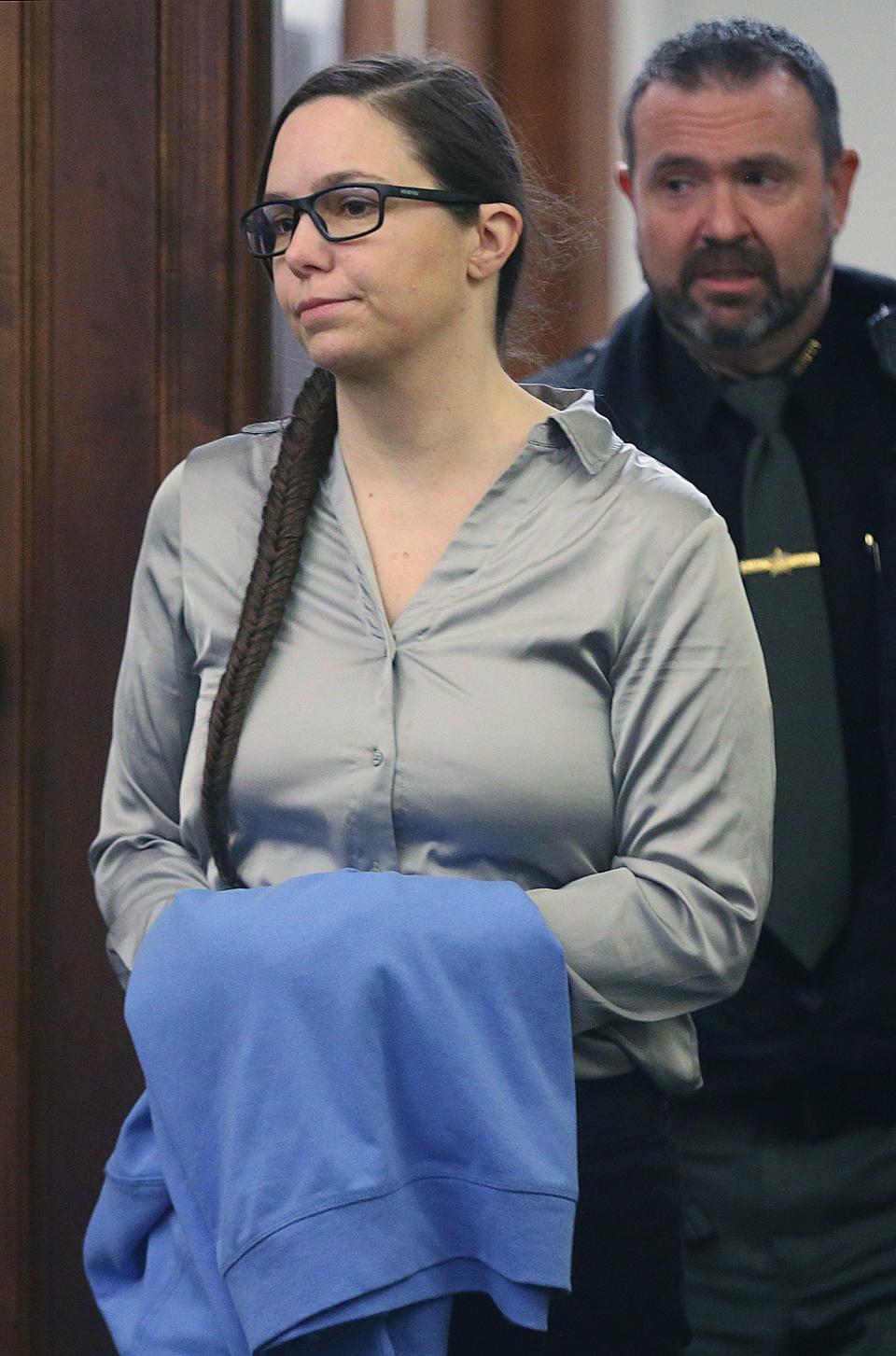 Erica Stefanko is escorted into Judge Jennifer Towell's courtroom on Monday for the start of her retrial in Summit County Common Pleas Court. Stefanko is accused of making the bogus pizza delivery call that lured Ashley Biggs to where she was killed in 2012.