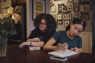 Gionna Durham, 13, left, spends time in the kitchen as her sister Grace Durham, 11, right, draws on Saturday, Jan. 27, 2024, in New York. It is hard to be a teenager today without social media. For those trying to stay off social platforms at a time when most of their peers are immersed, the path can be challenging, isolating and at times liberating. It can also be life-changing. (AP Photo/Andres Kudacki)