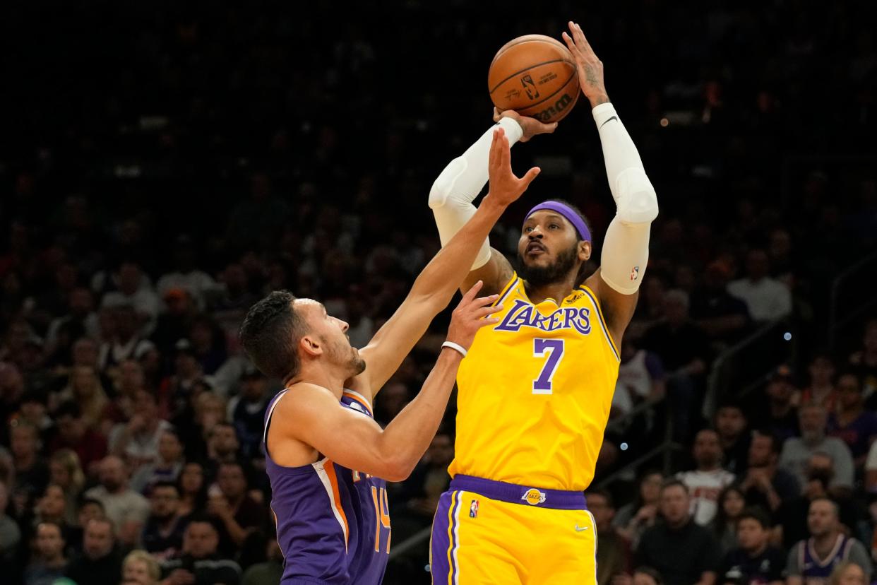 Los Angeles Lakers forward Carmelo Anthony (7) shoots over Phoenix Suns guard Landry Shamet during the first half of an NBA basketball game Tuesday, April 5, 2022, in Phoenix. (AP Photo/Rick Scuteri)