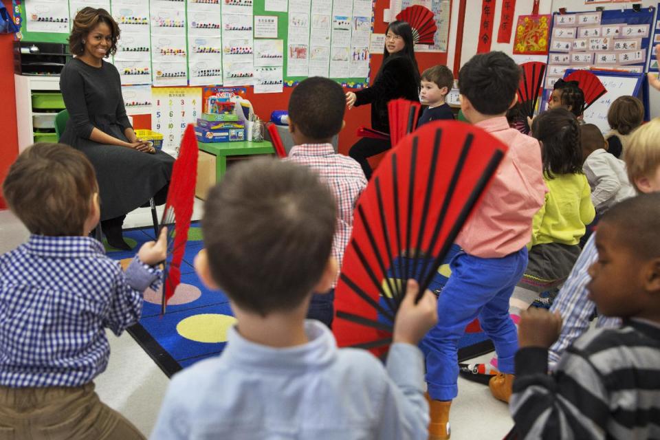 First lady Michelle Obama watches as pre-Kindergarten students perform a fan dance at Yu Ying Public Charter School in Washington, Tuesday, March 4, 2014. Later in March the first lady is expected to take a trip to China along with her daughters and mother. (AP Photo/Jacquelyn Martin)