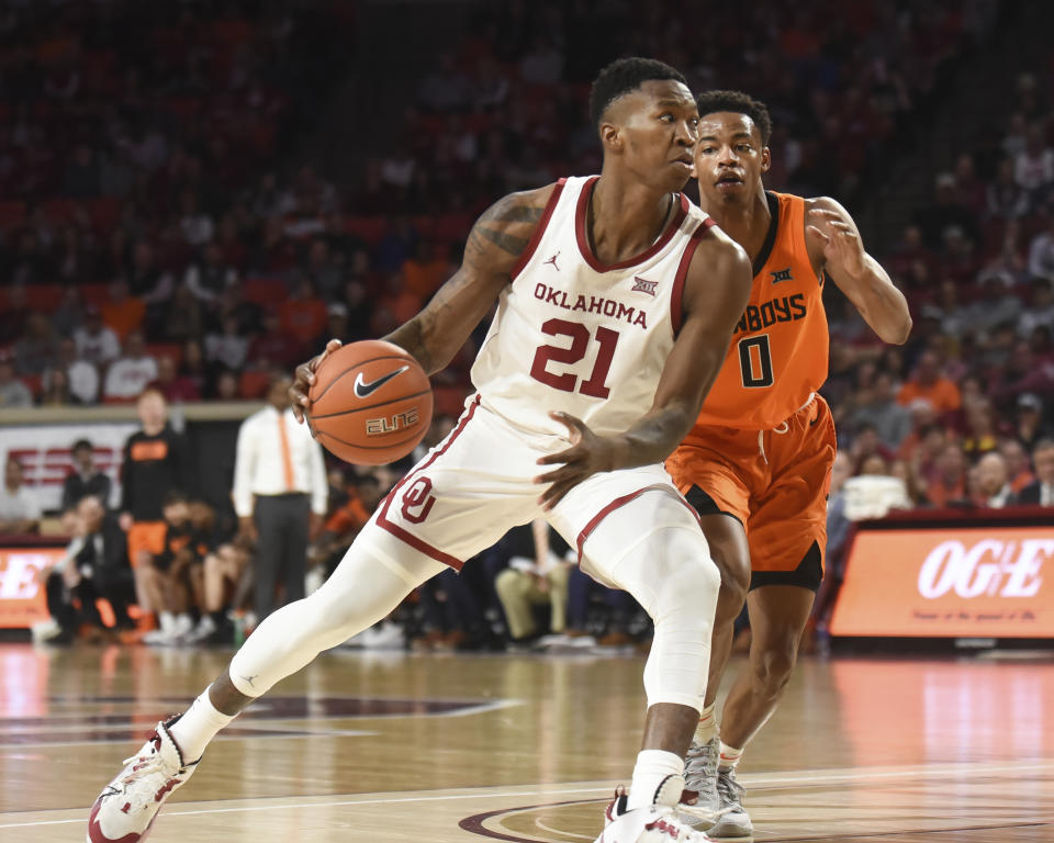 Oklahoma forward Kristian Doolittle (21) pushes past Oklahoma St guard Avery Anderson III (0) during the second half of an NCAA college basketball game in Norman, Okla., Saturday, Feb. 1, 2020. (AP Photo/Kyle Phillips)