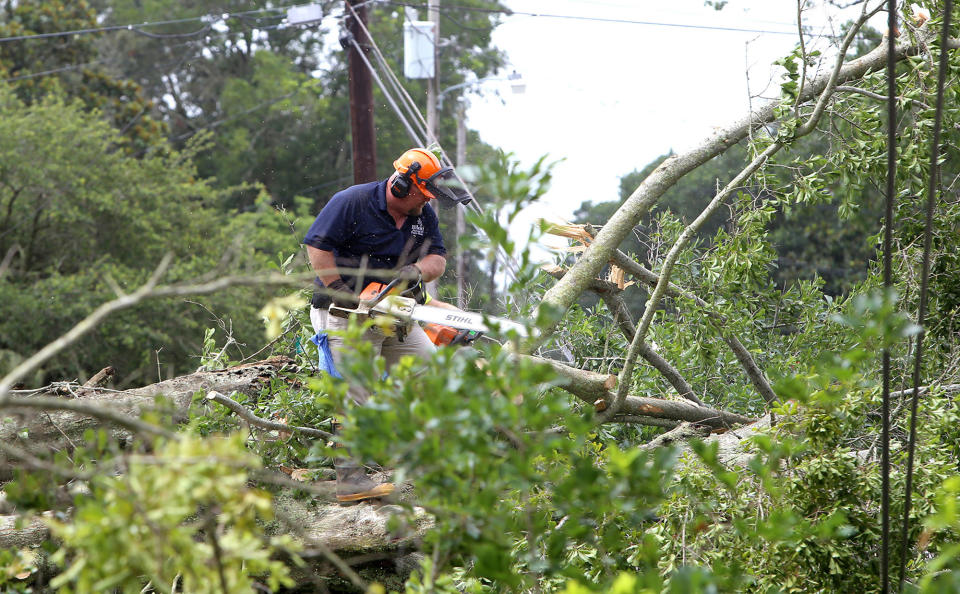 <p>Biloxi crews work to clear a downed tree from power lines on Rich Avenue on Wednesday, June 21, 2017 in Mississippi. The Mississippi Gulf Coast felt the effect of Tropical Storm Cindy for most of the day. (Photo: Tim Isbell/Biloxi Sun Herald/TNS via Getty Images) </p>