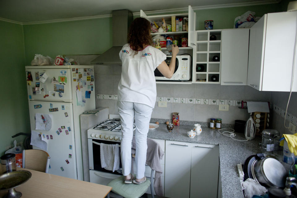 In this April 8, 2014 photo, Maria Eugenia Diez looks for food to prepare her children's lunch at her home in Buenos Aires, Argentina. "We have to think it over 25 times before going out to eat," Diez, a middle-class housewife said. On Thursday, April 10, 2014, a nationwide strike paralyzed Argentina’s public transportation, all non-emergency hospital attention and other sections of public life. Diez, a middle-class housewife, says she's sympathetic to the union workers' salary woes and supports many of the government's efforts to direct resources to the poor, but thinks the strike just takes more money from everyone's pockets. (AP Photo/Victor R. Caivano)