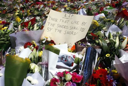 A note can be seen amongst floral tributes that have been placed near the cafe where hostages were held for over 16-hours, in central Sydney December 16, 2014. REUTERS/David Gray