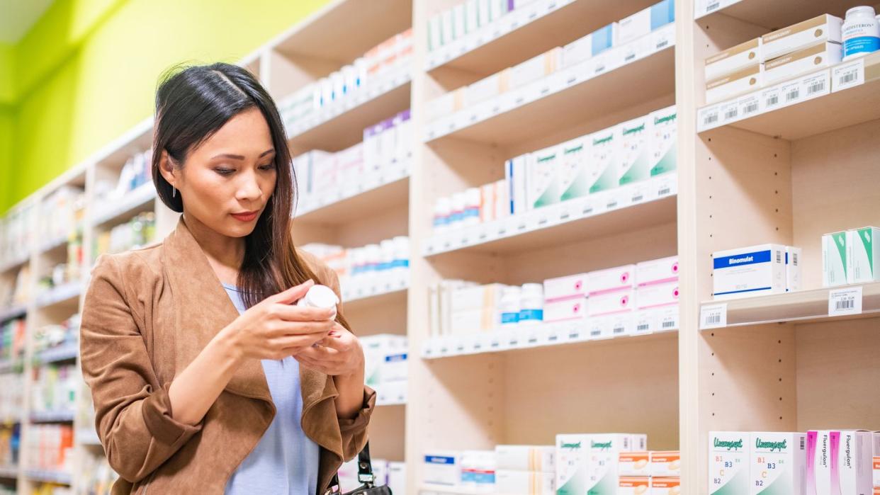 woman reading medicine bottle label