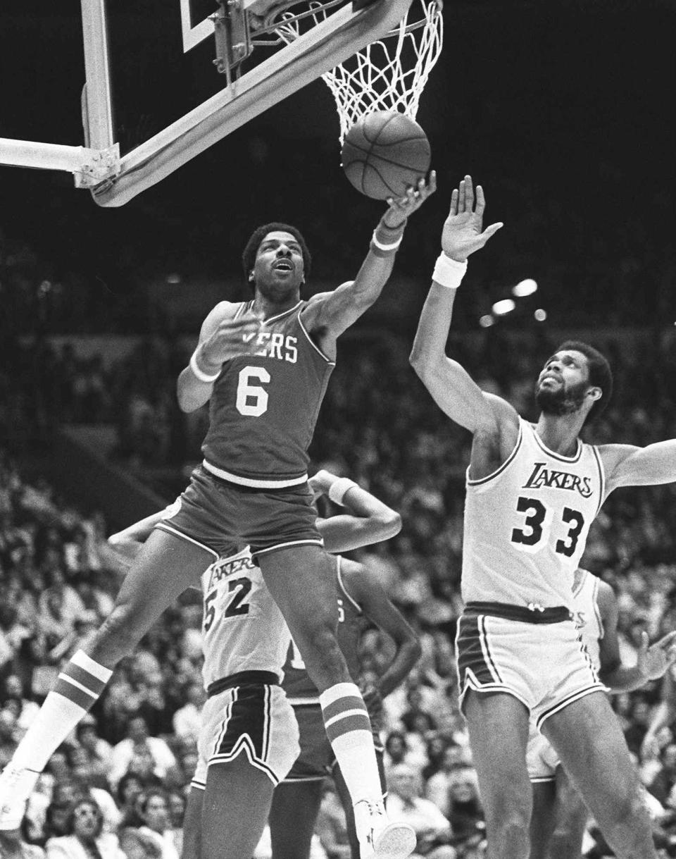 Philadelphia 76ers Julius Erving (6) goes up and around the basket to score against Lakers center Kareem Abdul-Jabbar (33) during the 1980 NBA Finals.