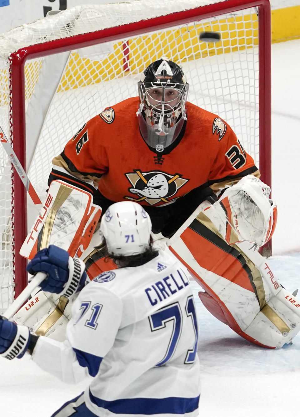 Anaheim Ducks goaltender John Gibson, top, watches the puck fly along with Tampa Bay Lightning center Anthony Cirelli during the first period of an NHL hockey game Friday, Jan. 21, 2022, in Anaheim, Calif. (AP Photo/Mark J. Terrill)