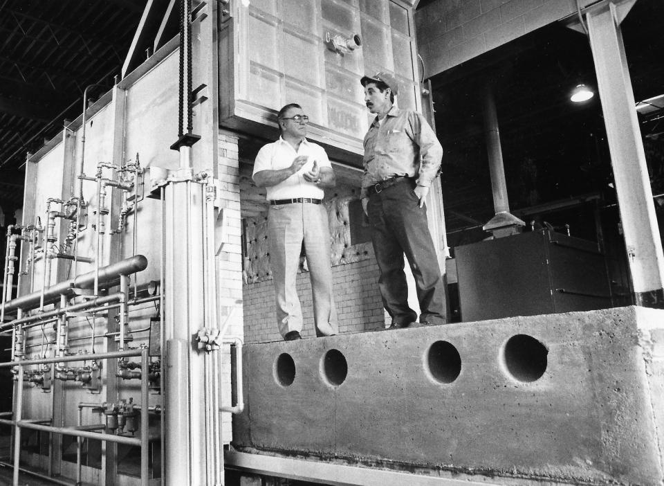 Akron Steel Treating Co. owner Prosper Powell and worker Frank Manzo stand on the movable shelf of a furnace in 1981 at the South Broadway plant.