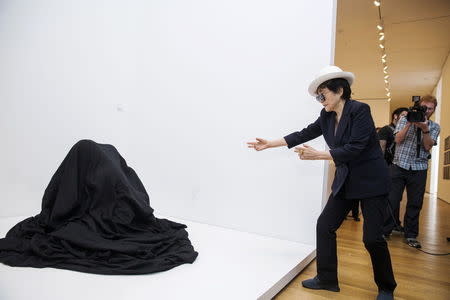 Artist Yoko Ono dances near the exhibit "Bag Piece" at the Museum of Modern Art exhibition dedicated exclusively to her work, titled "Yoko Ono: One Woman Show, 1960-1971", in New York May 12, 2015. REUTERS/Lucas Jackson